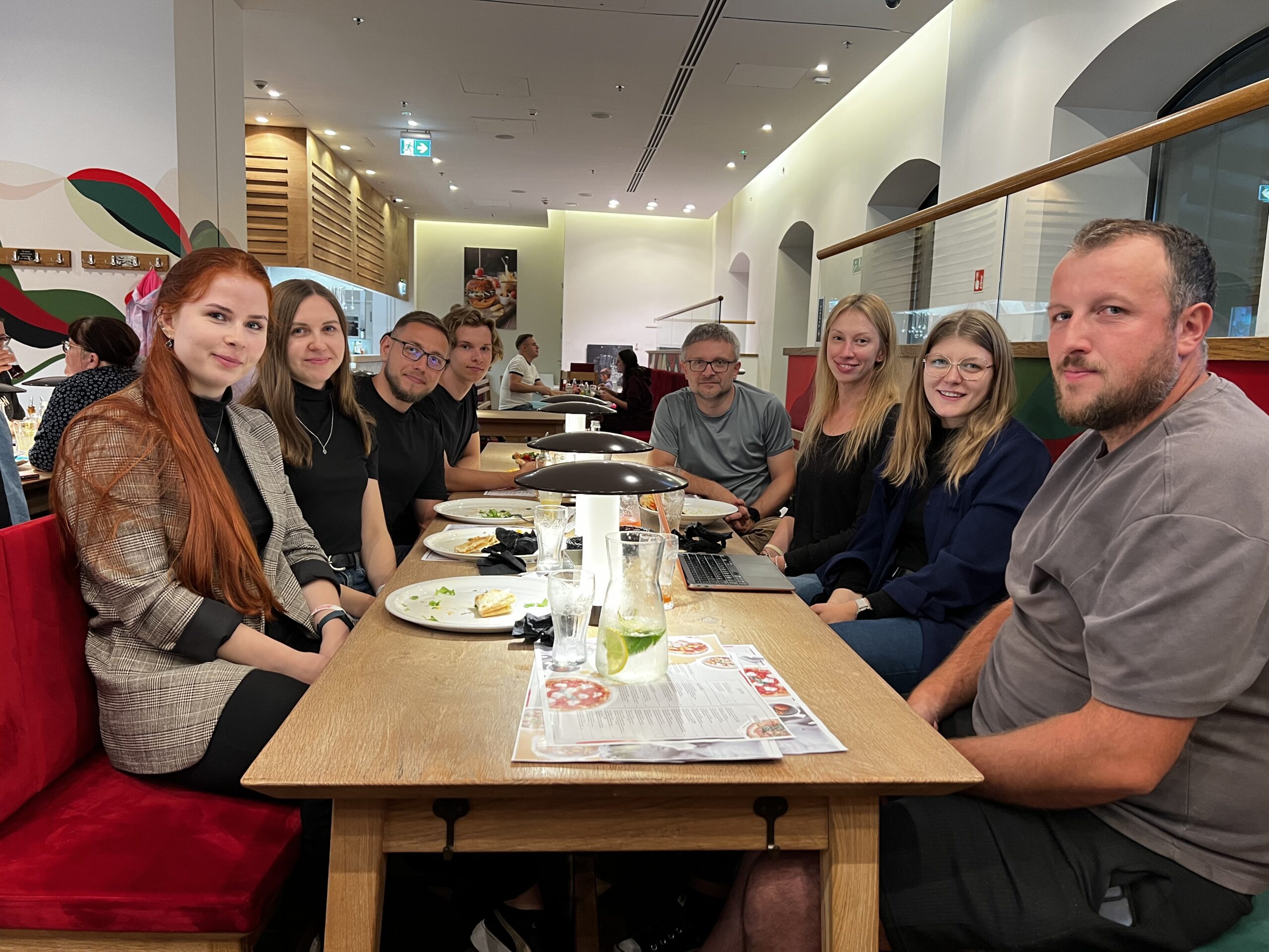 Grupa ludzi w restauracji przy stole.